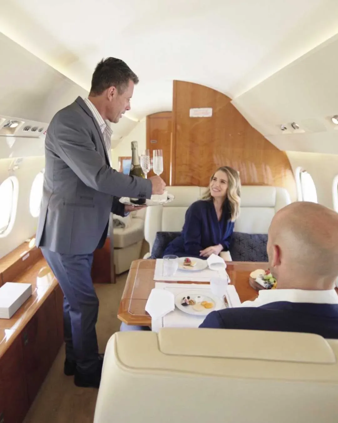 Cabin attendant serving guests on a private jet