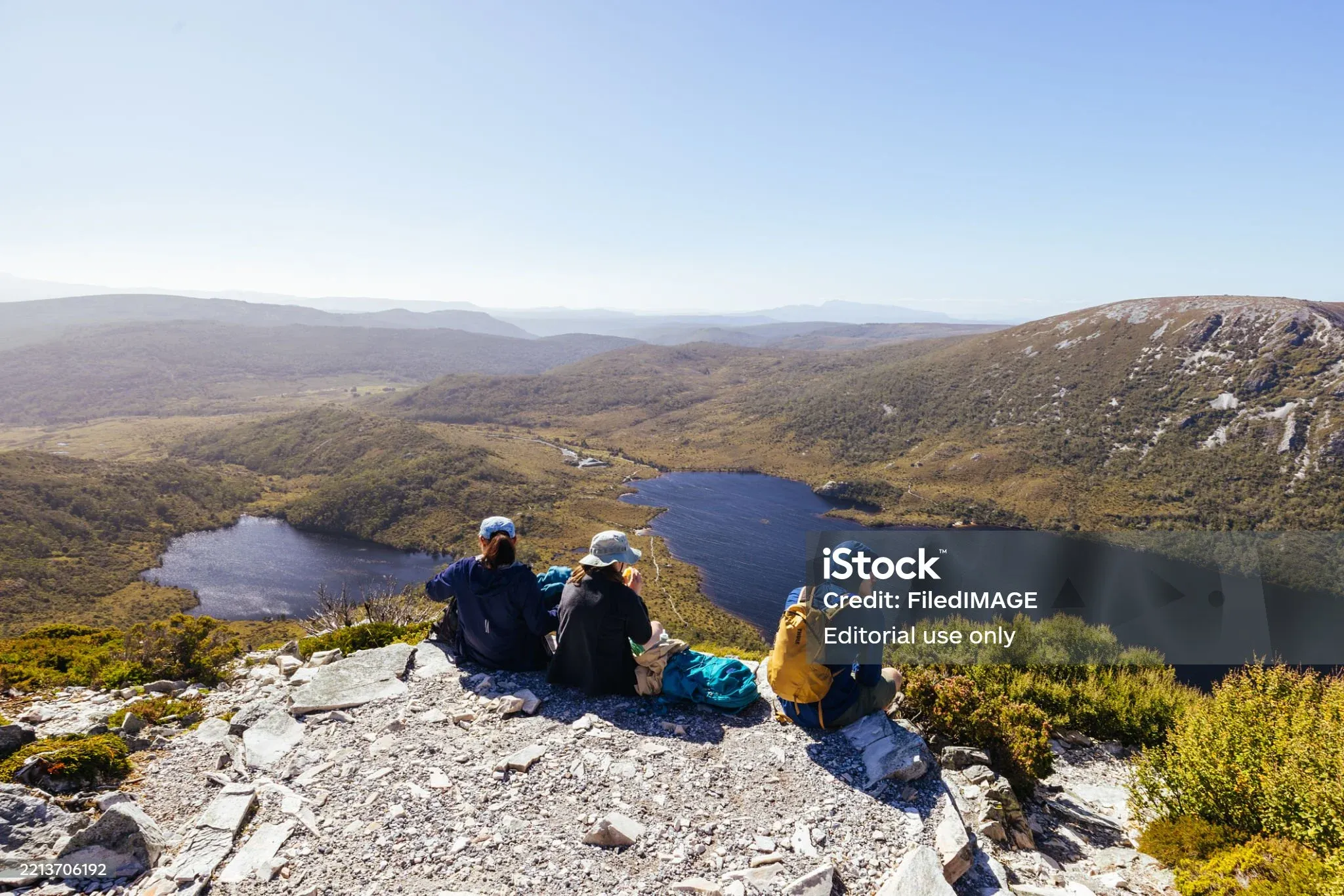 Walkers resting above a mountain lake
