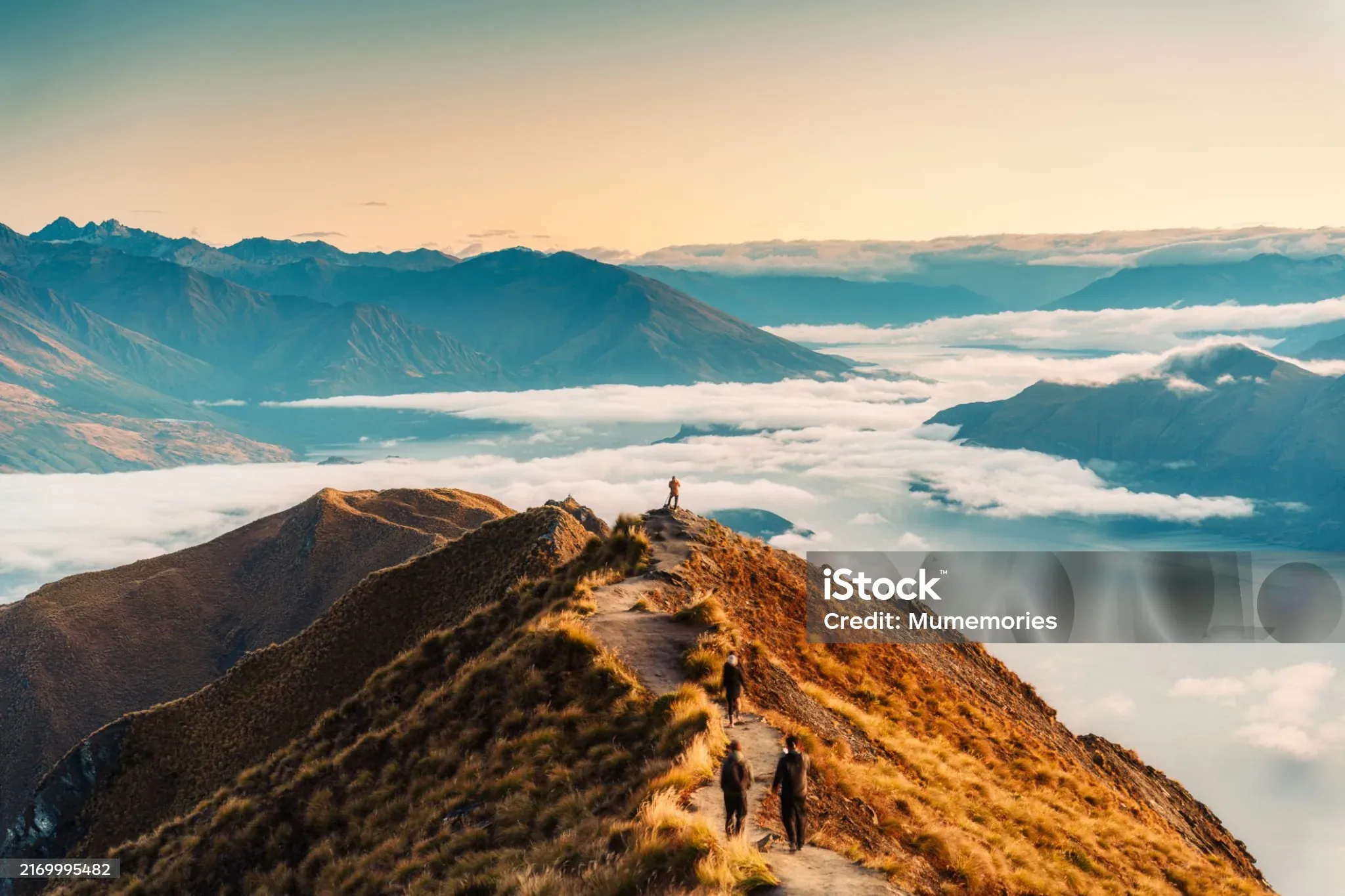 Hikers on a ridge above the clouds in New Zealand