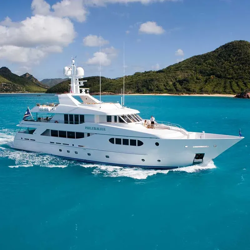 Superyacht cruising past a green headland